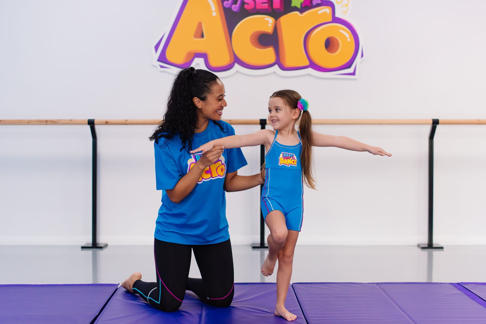 Acro Instructor Assists Young Girl In A Balancing Pose. Studio Setting. They Both Smile — Dance Express Mackay In North Mackay, QLD