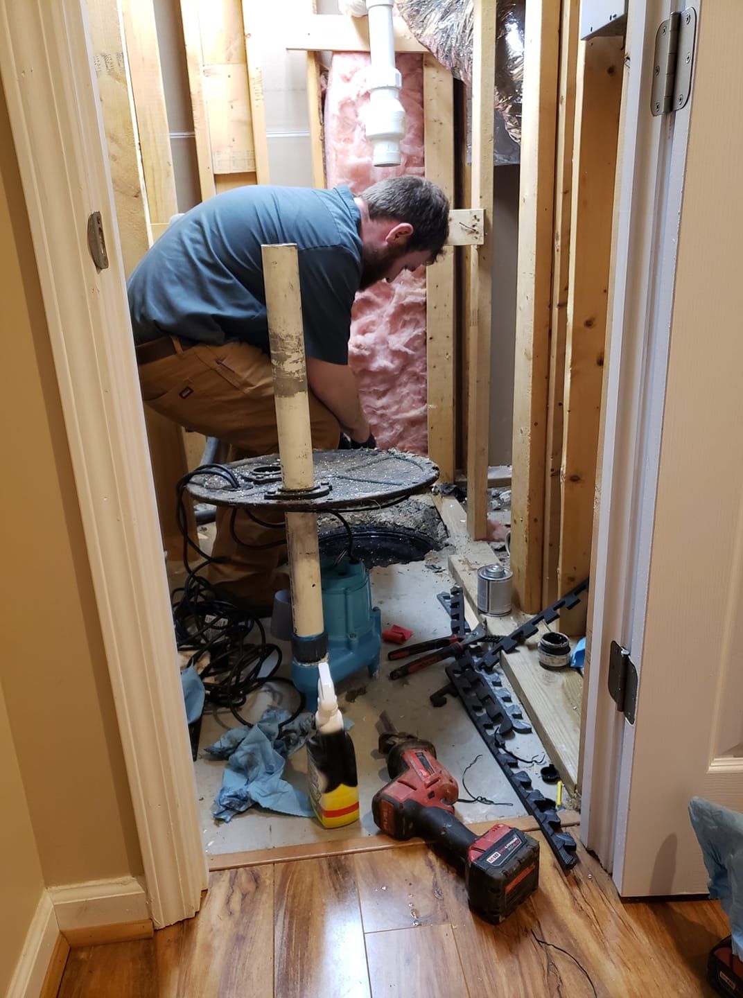 A man is working on a pipe in a basement.