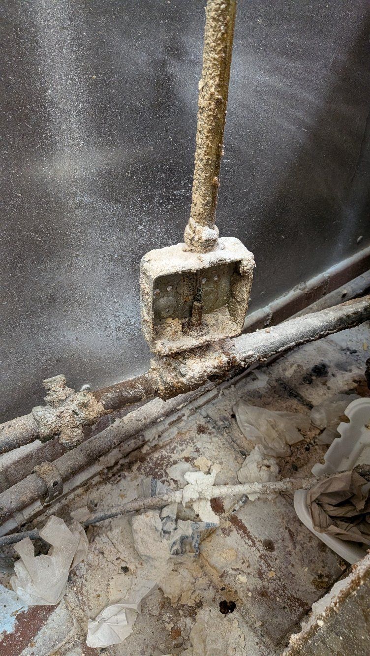 Dirty construction tool leaning against a wall in a dusty, debris-covered area