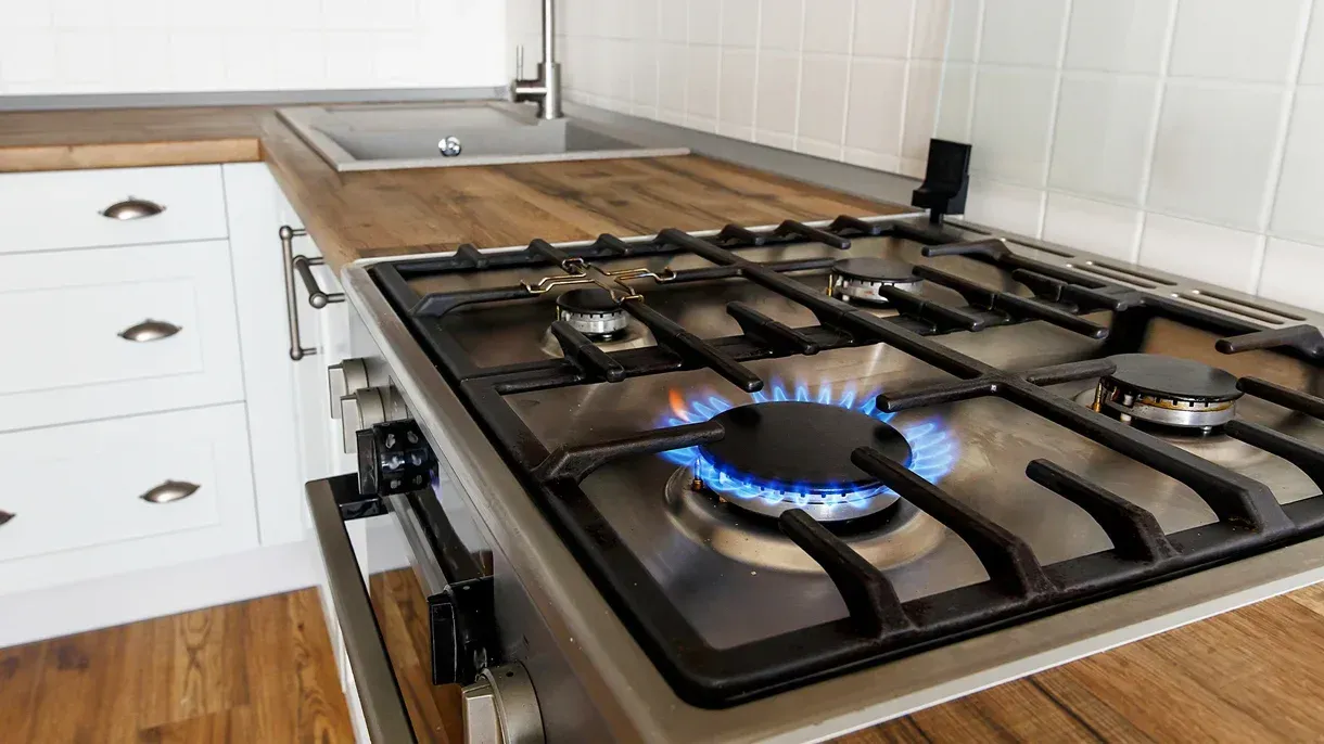 A gas stove with a blue flame on it in a kitchen.