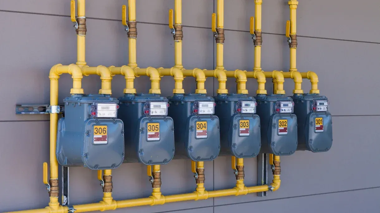 A row of gas meters attached to a wall.