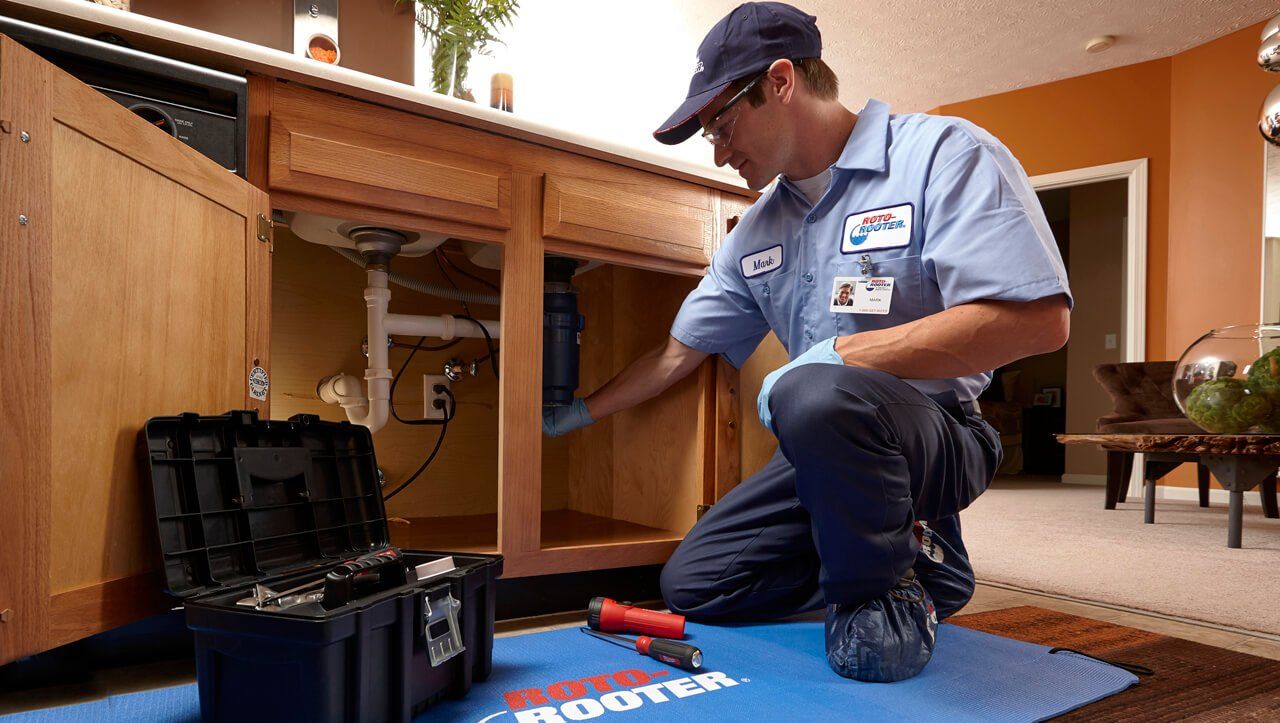 Roto-Rooter tech repairing garbage disposal