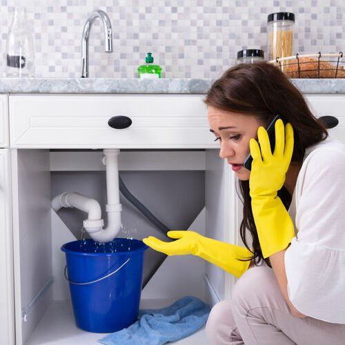 women with water leak under sink