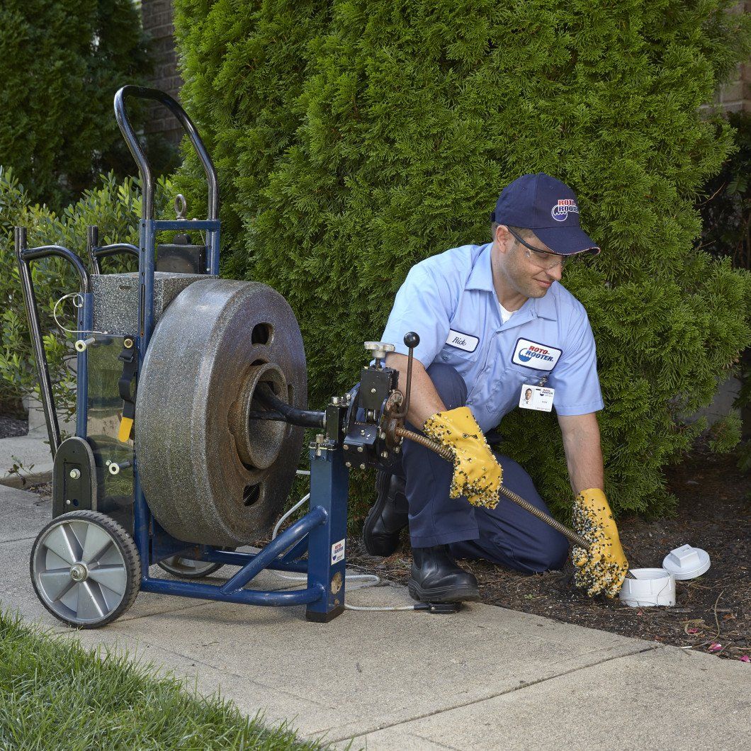 Roto-Rooter tech snaking outside cleanout