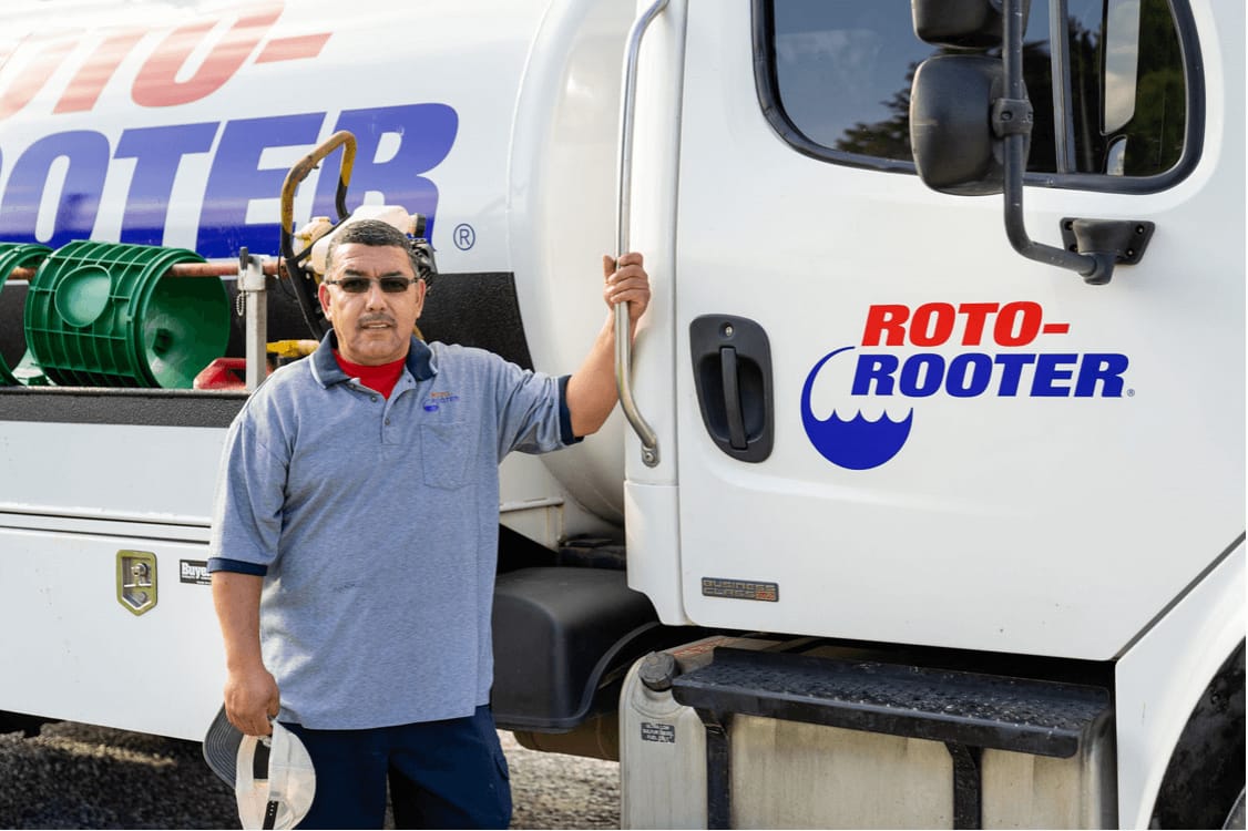 Roto-Rooter tech standing with truck