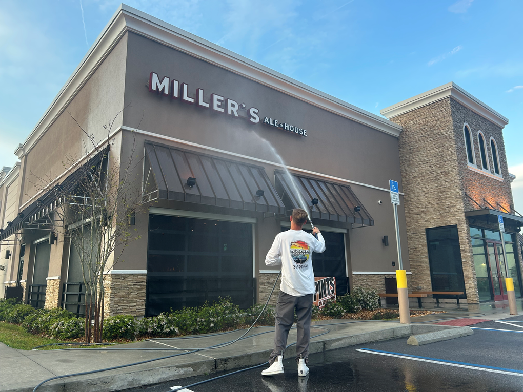Miller’s storefront with striped awning and a person standing outside in the parking lot