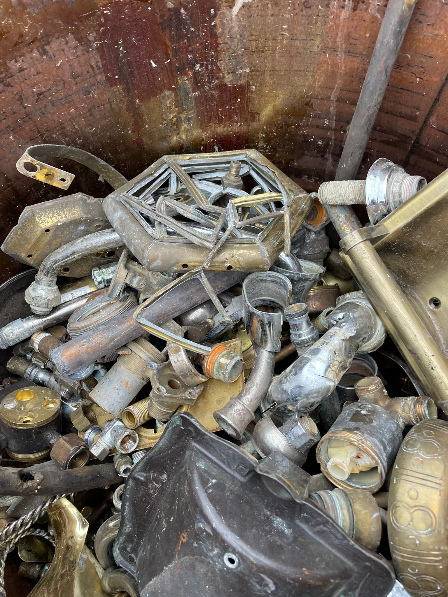 Pile of discarded metal and plastic scrap in a rusty container