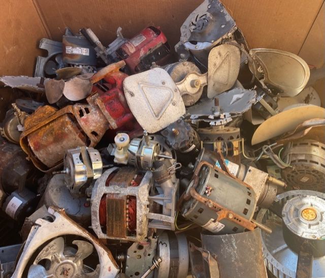 Box of assorted old metal machinery parts and housings in rusted gray, red, and beige colors