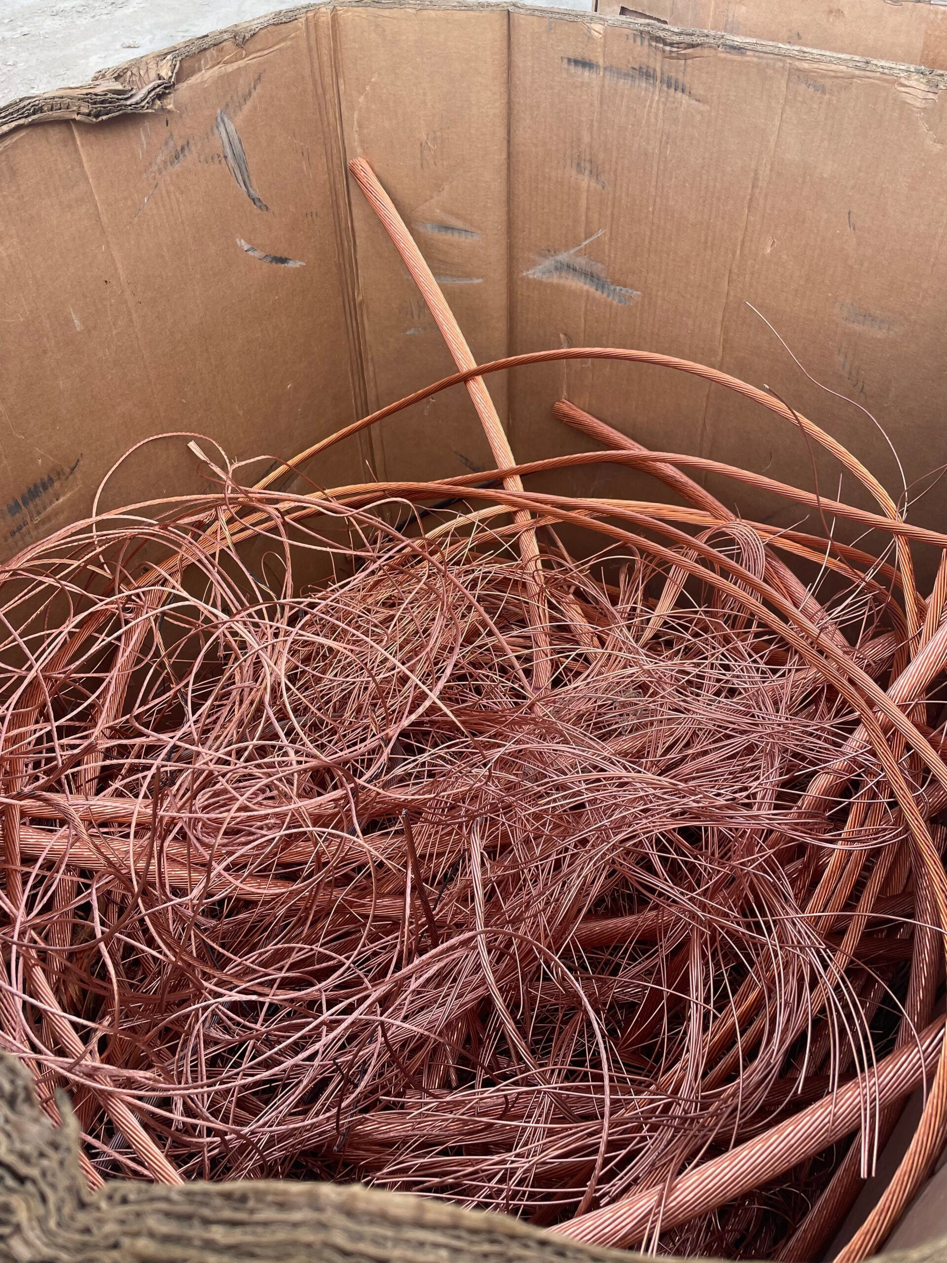 Coiled copper wire scraps in a cardboard box