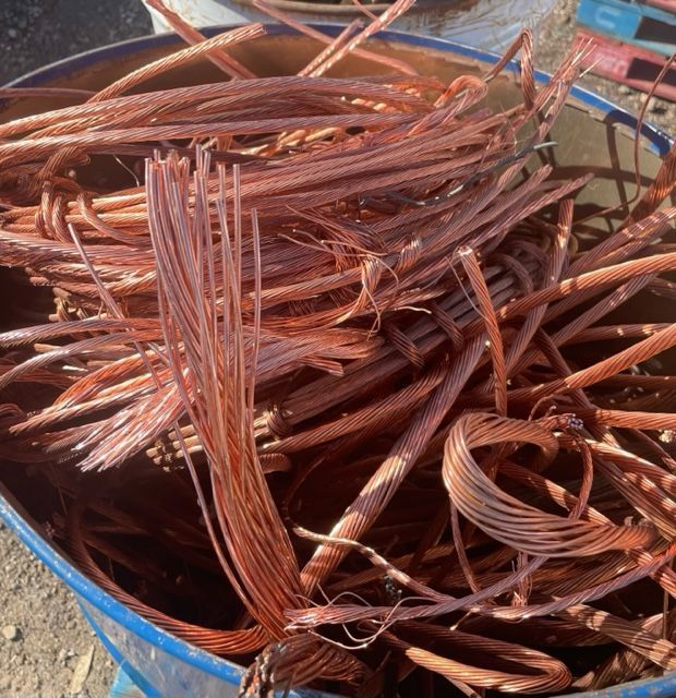 Pile of stripped copper wires and cables in a bin outdoors