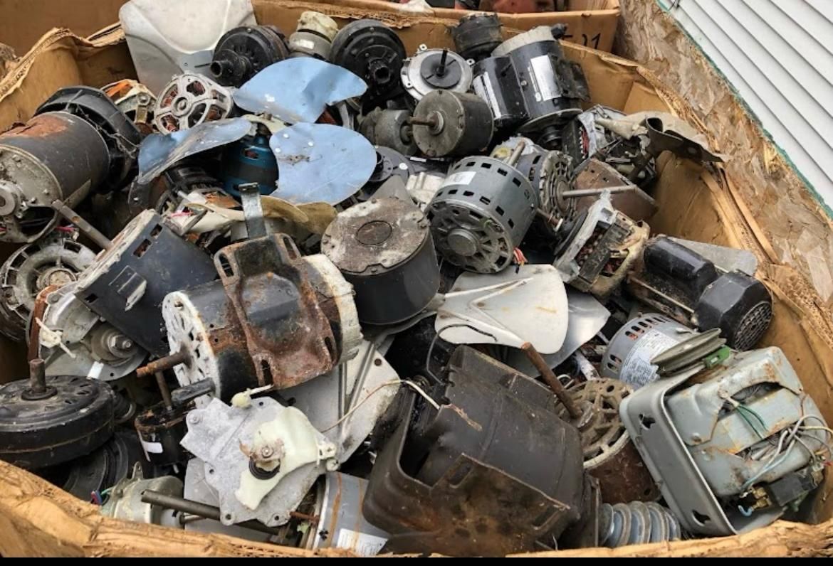 Pile of old, broken motors and mechanical parts in a cardboard box