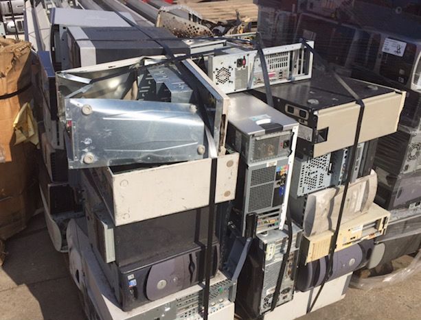 Pile of stacked scrap metal and old electronics in an outdoor junkyard.