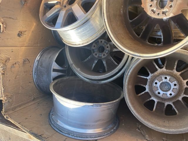 Stacked car wheels and rims in a dusty storage area