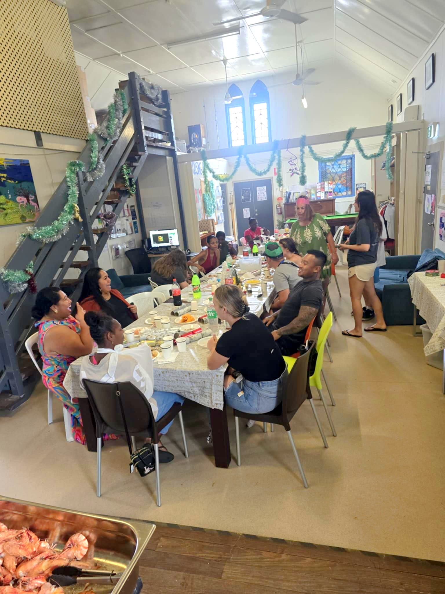A Group of People Sit Around a Long Dining Table — Tre's Food To You in Mount Sheridan, QLD