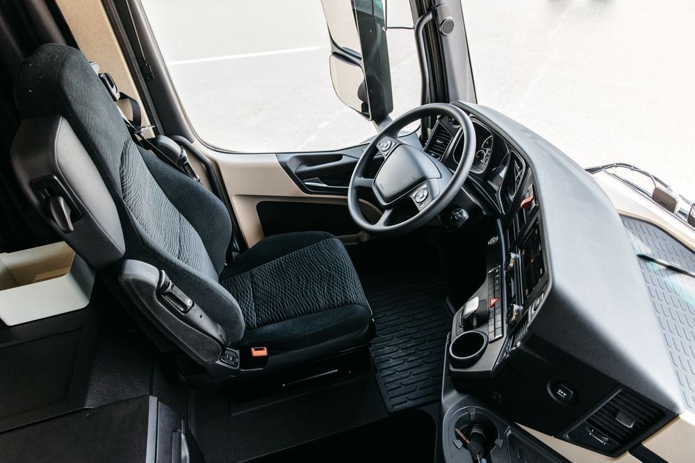 Interior view of a black Ram truck with a large touchscreen display, steering wheel, and dashboard.