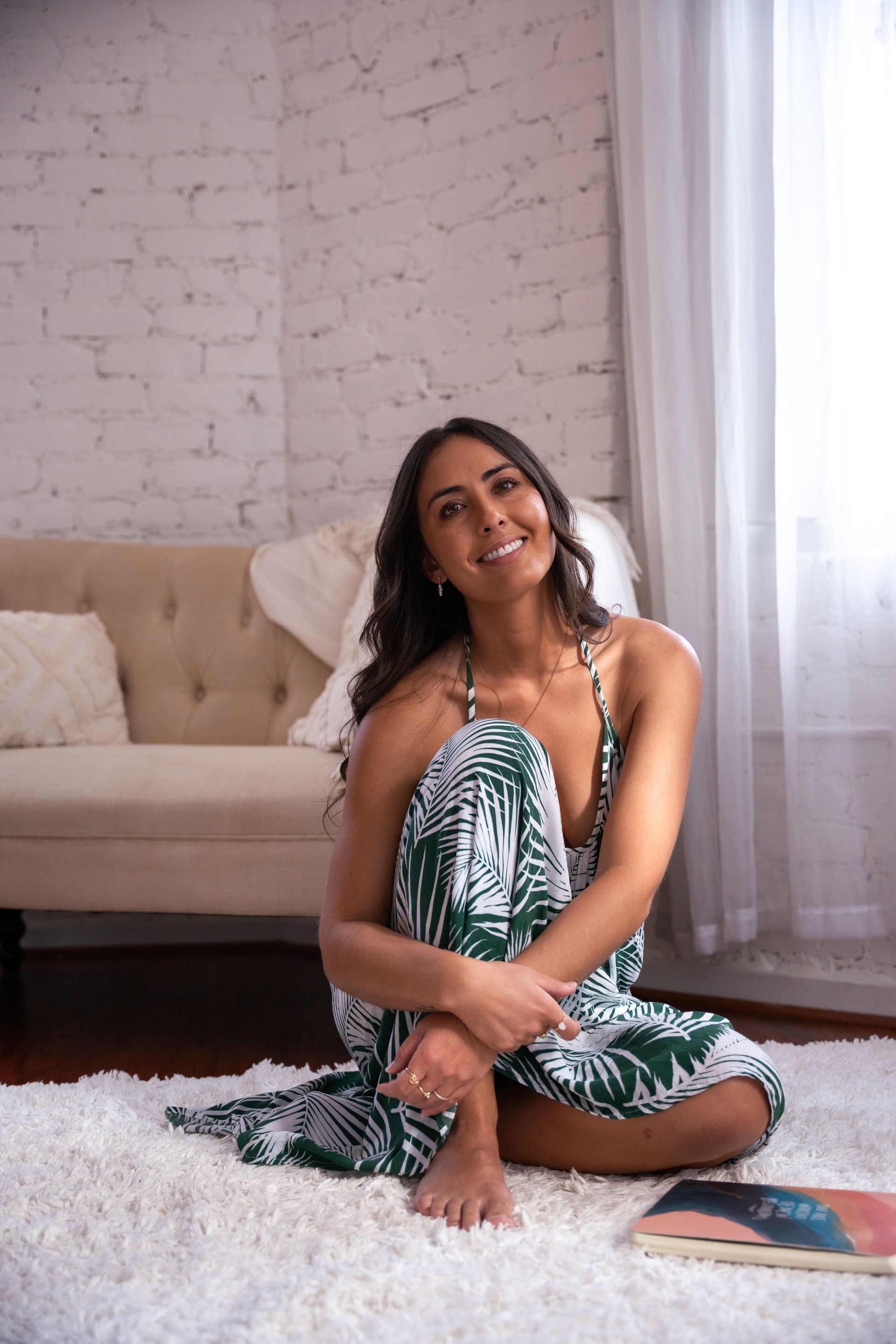 pmdd coach sitting on the ground in a green and white dress smiling