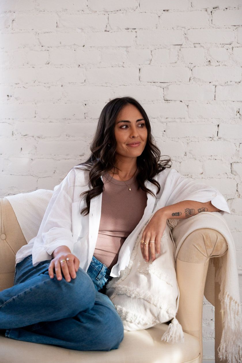 a women's pmdd coach sitting on a coach looking off to the side