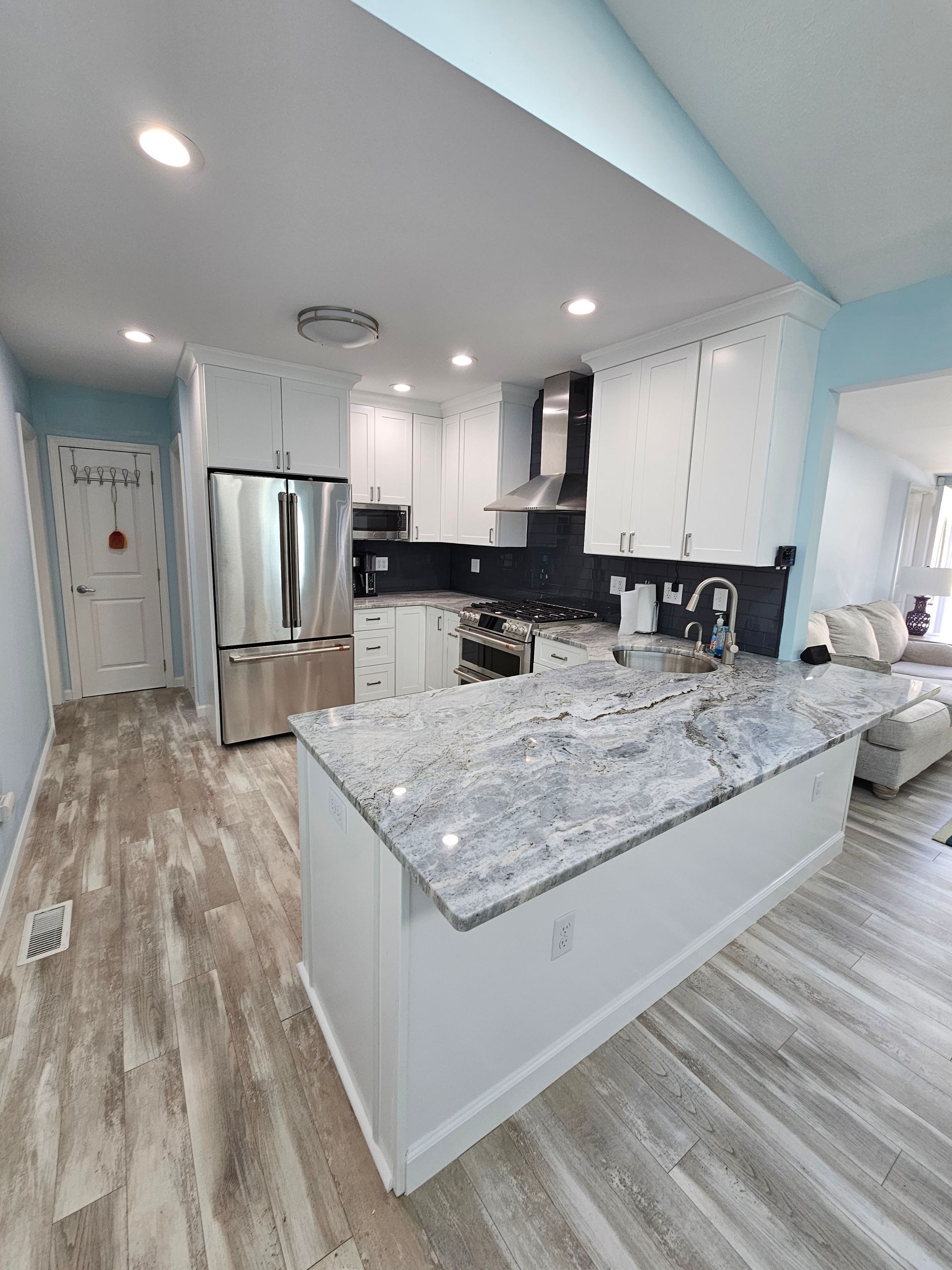 A kitchen with granite counter tops and stainless steel appliances.