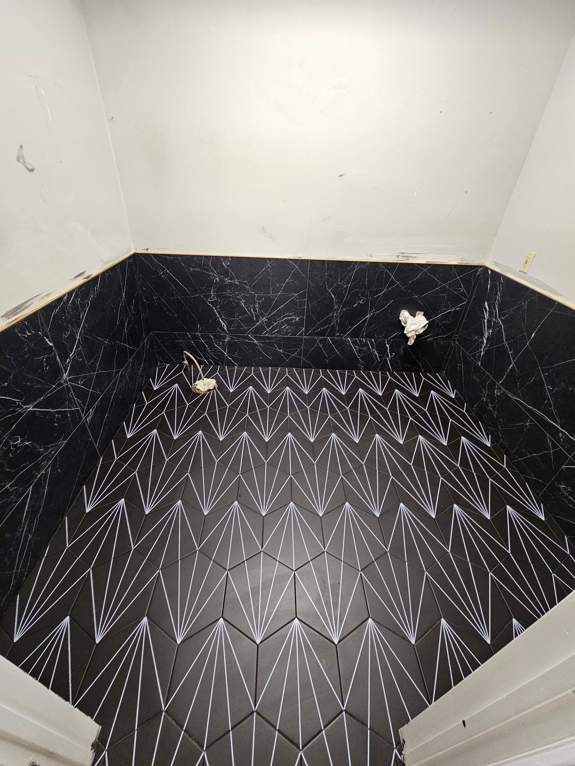 A room with a black tile floor and a white wall.