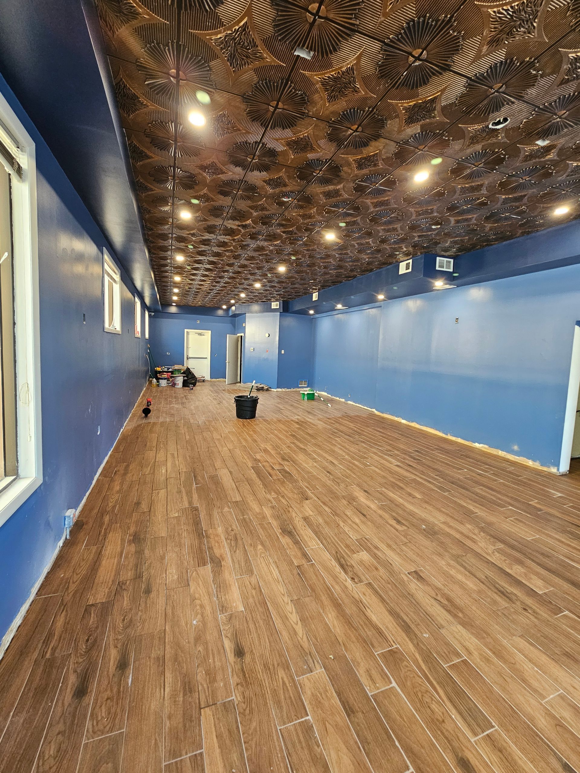A large empty room with blue walls and a wooden floor.