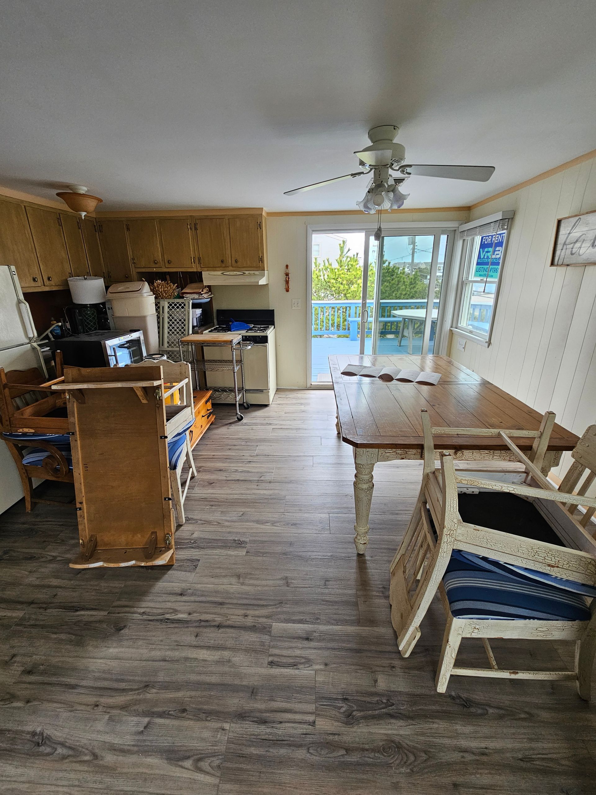 Kitchen area with wood cabinets, table, chairs, and sliding glass door to a patio.