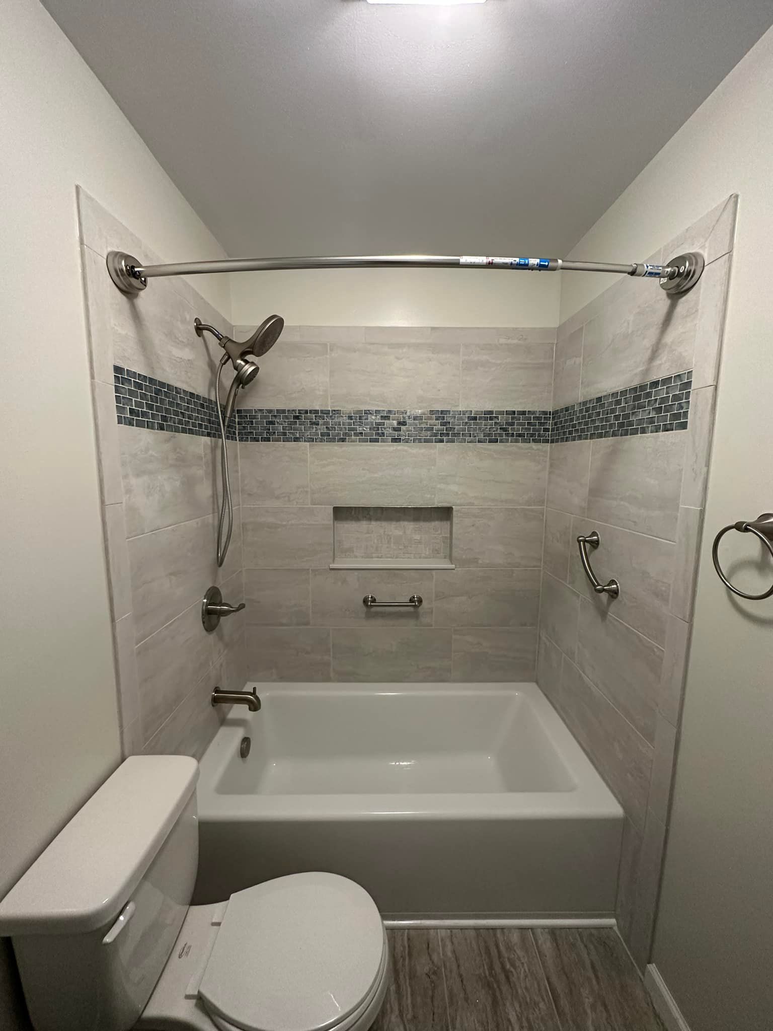 A bathroom with a toilet , bathtub and shower.