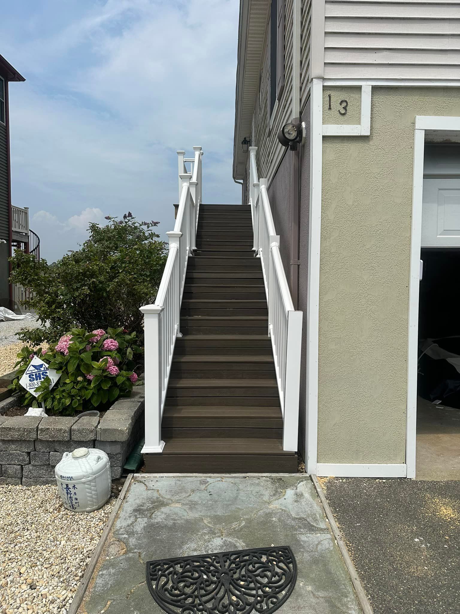 A set of stairs leading up to a house with a white railing.