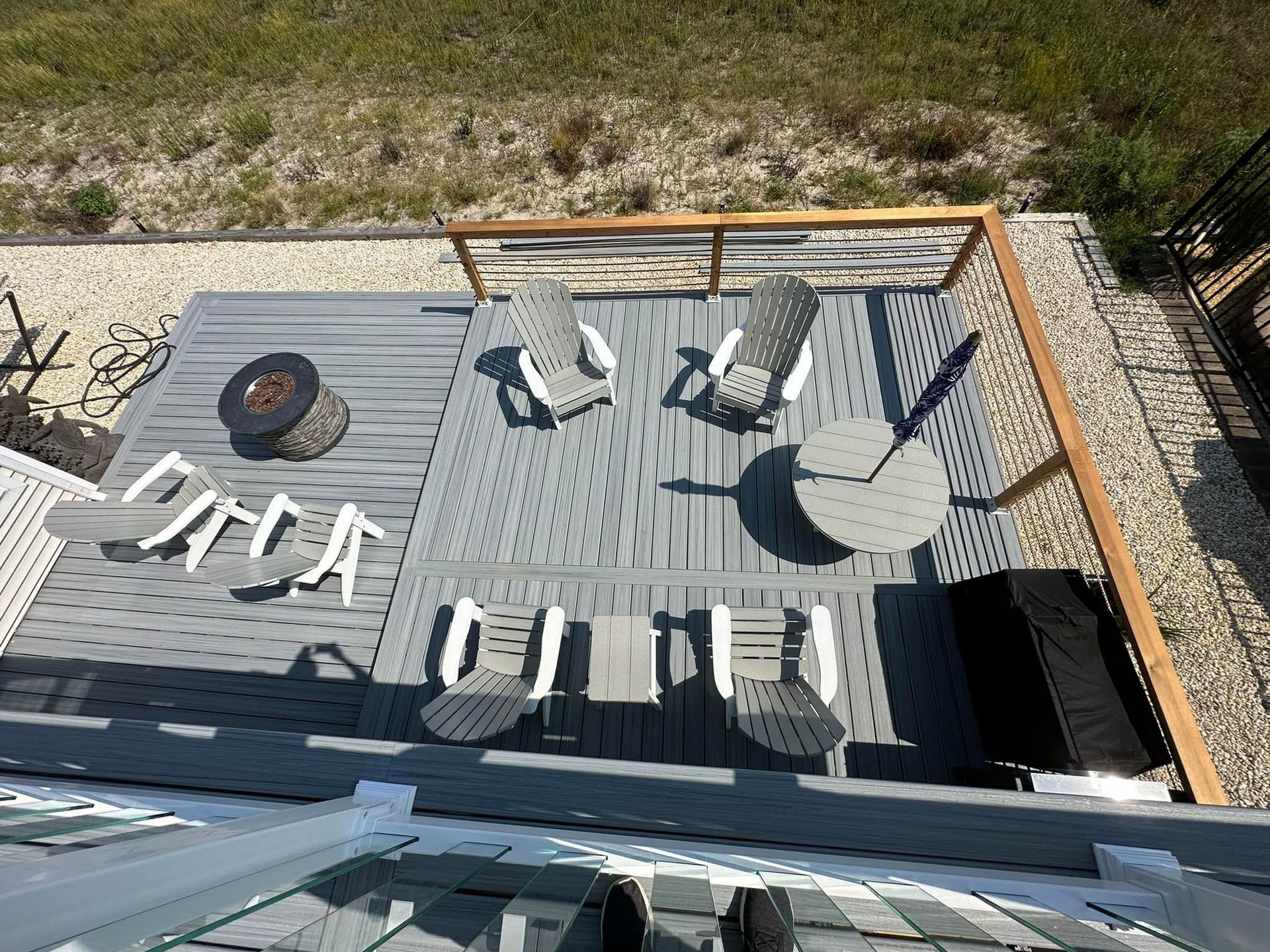 An aerial view of a deck with chairs and a fire pit.