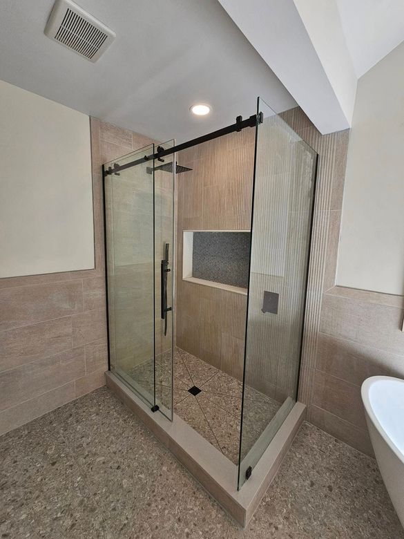 A bathroom with a sink , toilet , shower and mirror.