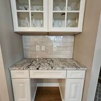 White hutch with glass-door cabinets over a countertop and cabinetry.