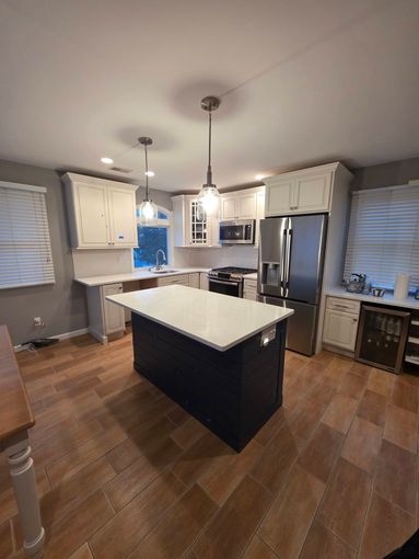 A kitchen with white cabinets and stainless steel appliances