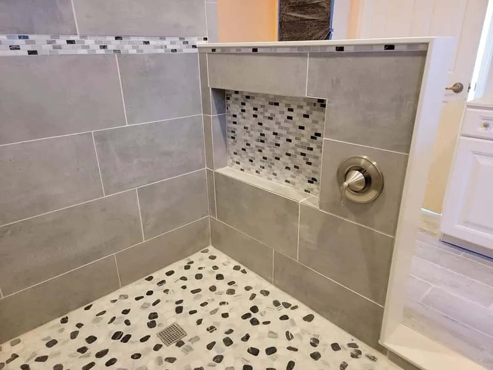 A bathroom with a walk in shower and a niche in the wall.