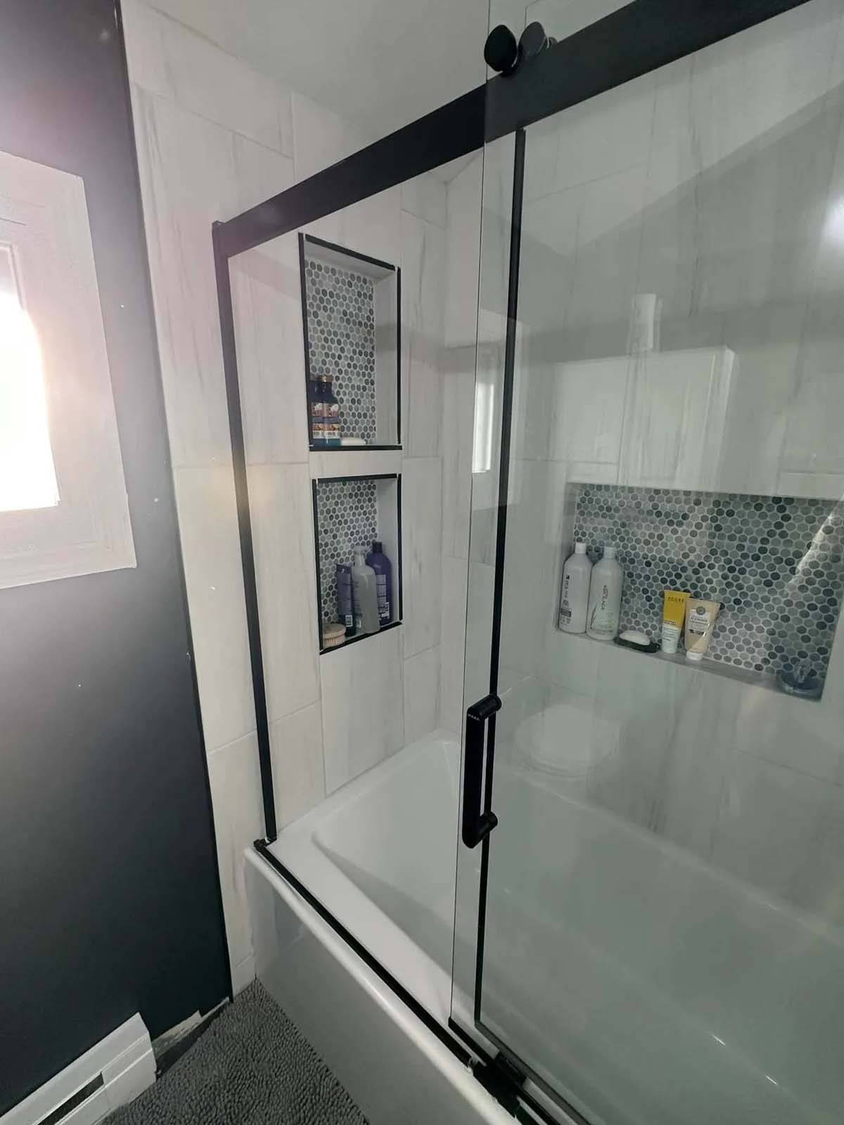 A bathroom with a bathtub and a sliding glass shower door.