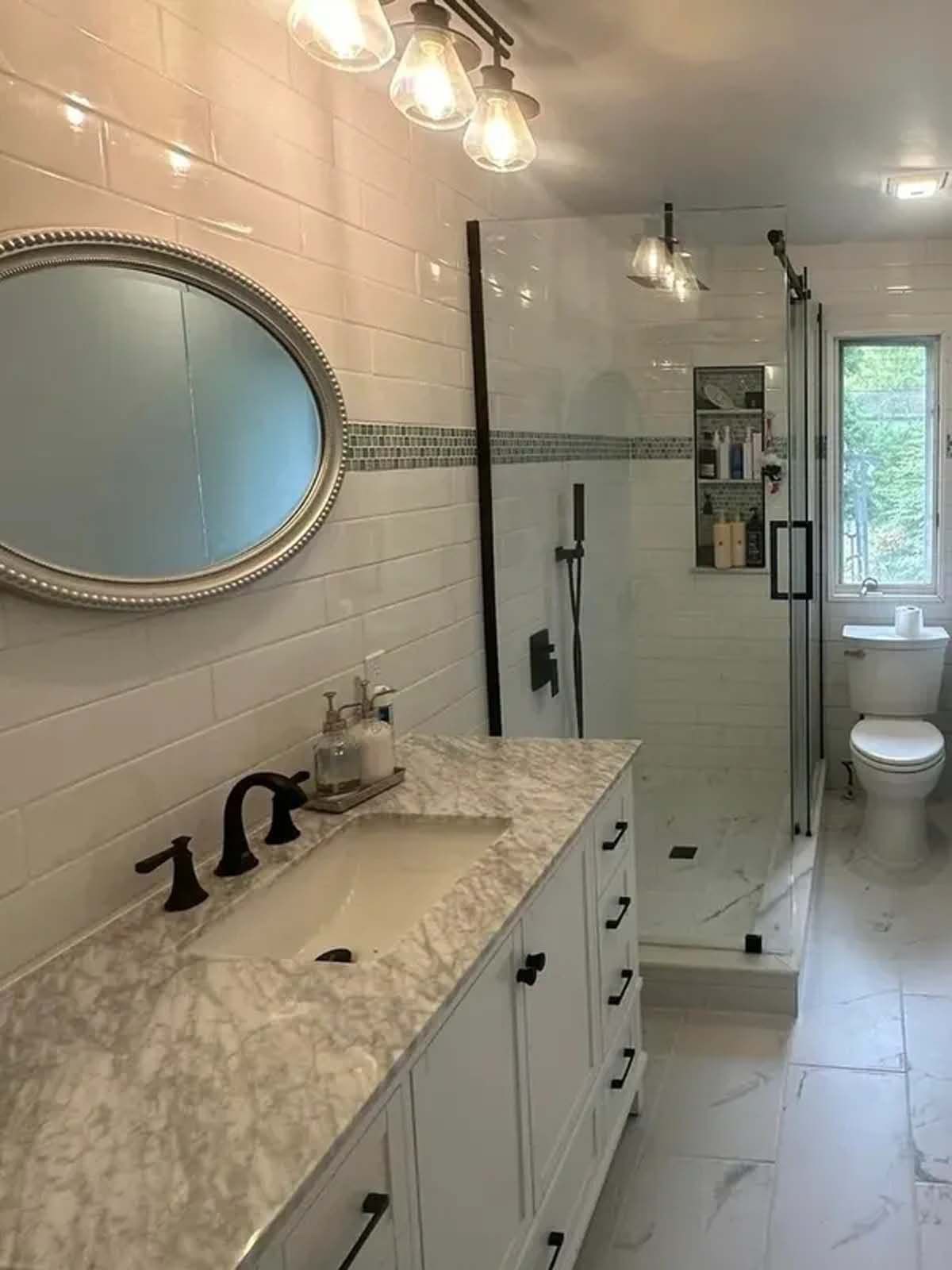 A bathroom with a sink , toilet , shower and mirror.