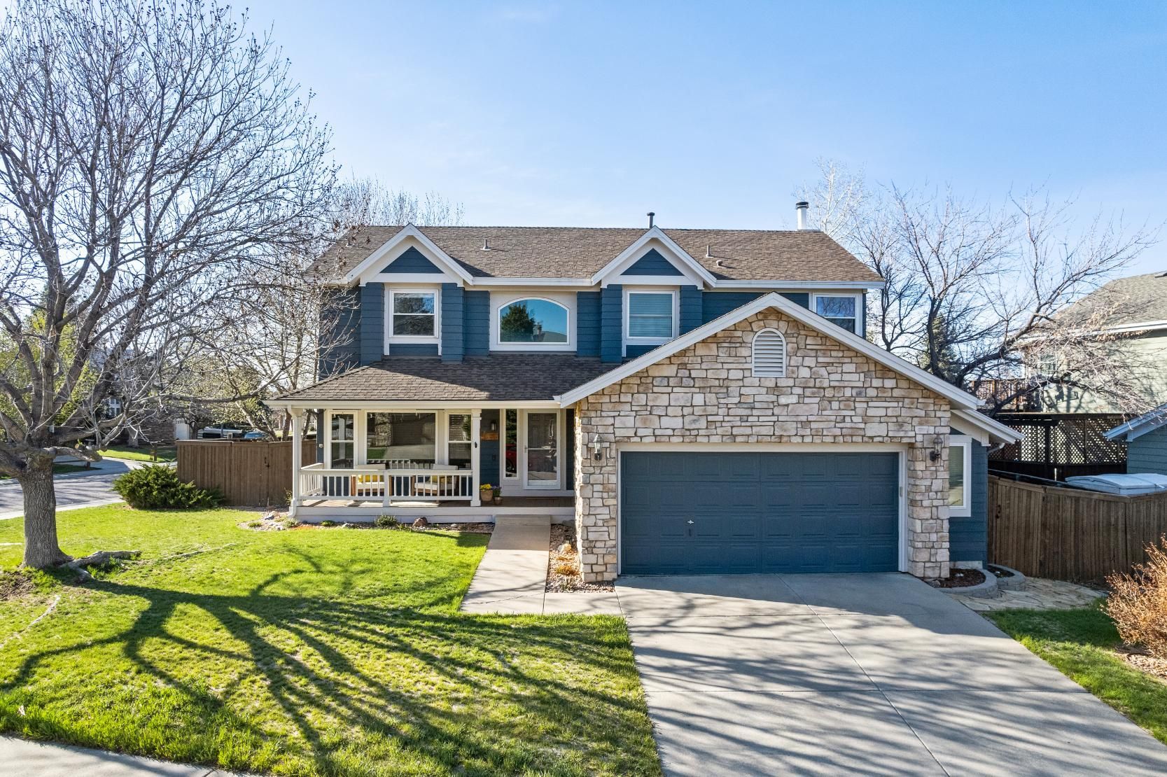 a large house with a blue roof and a blue garage door is for sale .