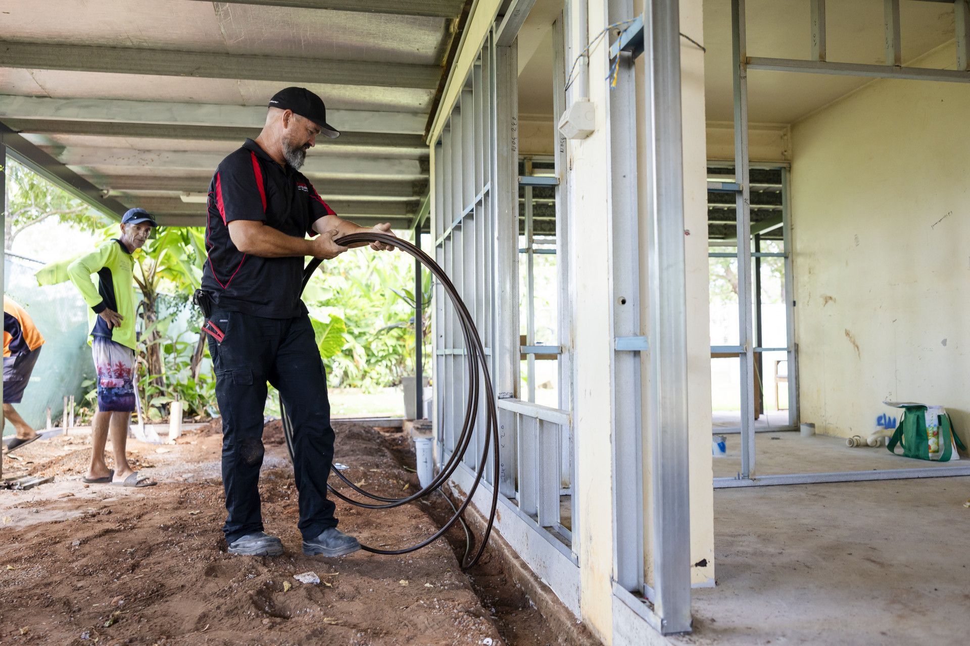 A Man Inspecting on the Ground in Front of a Building — Quack Pest Control in Winnellie, NT