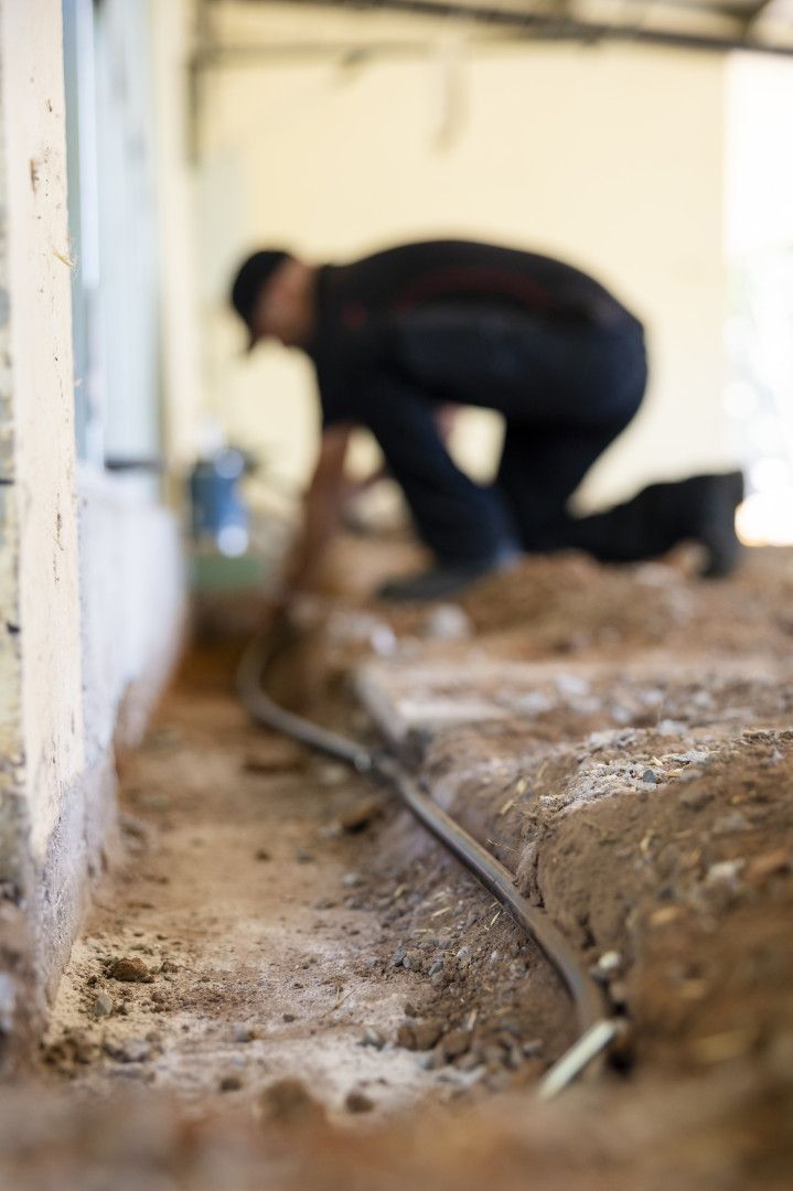 A Man laying Black Piping— Quack Pest Control in Winnellie, NT