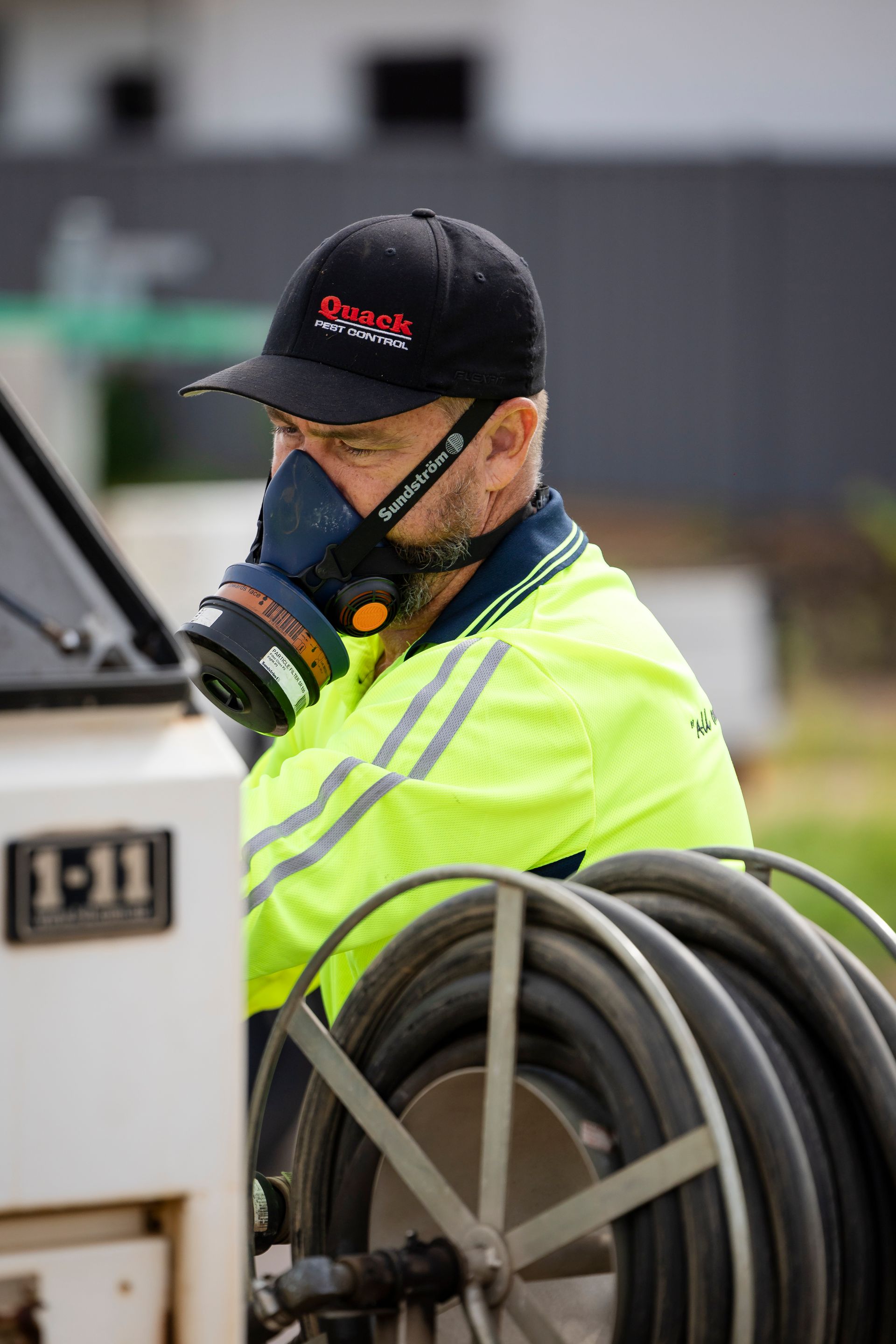 A Man With Mask Next To Black Piping — Quack Pest Control in Winnellie, NT