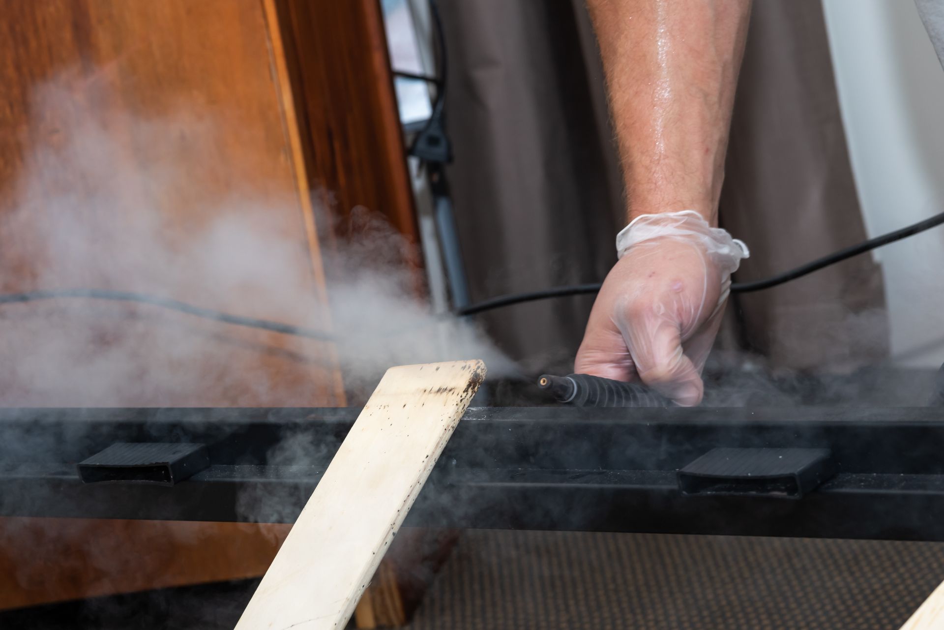 Person Steaming a Black Metal Frame With Wood, Creating Steam — Quack Pest Control in Winnellie, NT