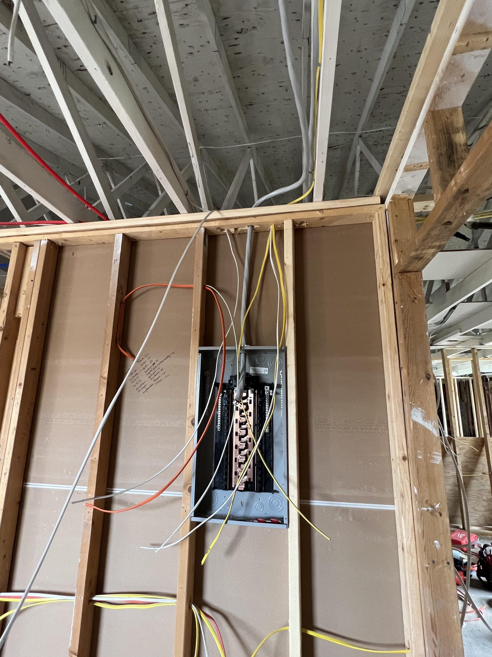 NS Electric electrician wiring a breaker box in new construction