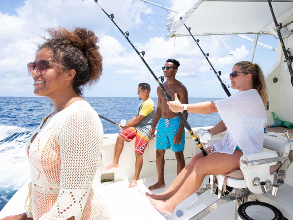 A group of people are fishing on a boat in the ocean.