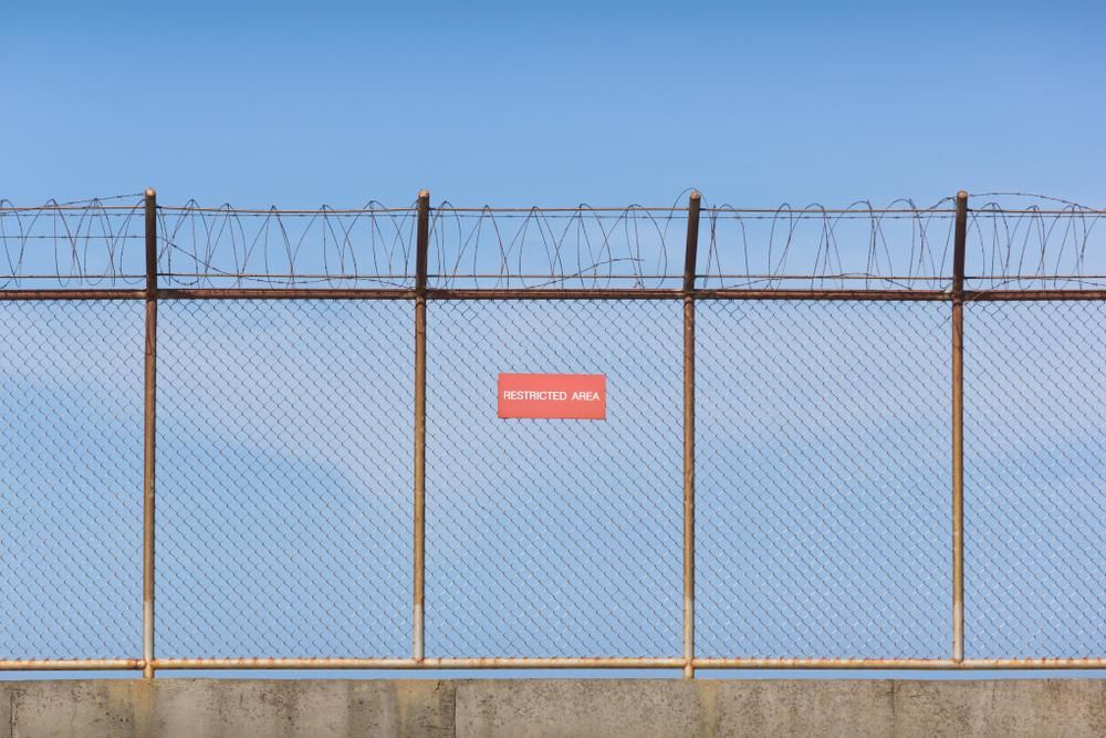 A Chain Wire Fence with A Red Sign on It — Byron & Beyond Fencing In Billinudgel, NSW