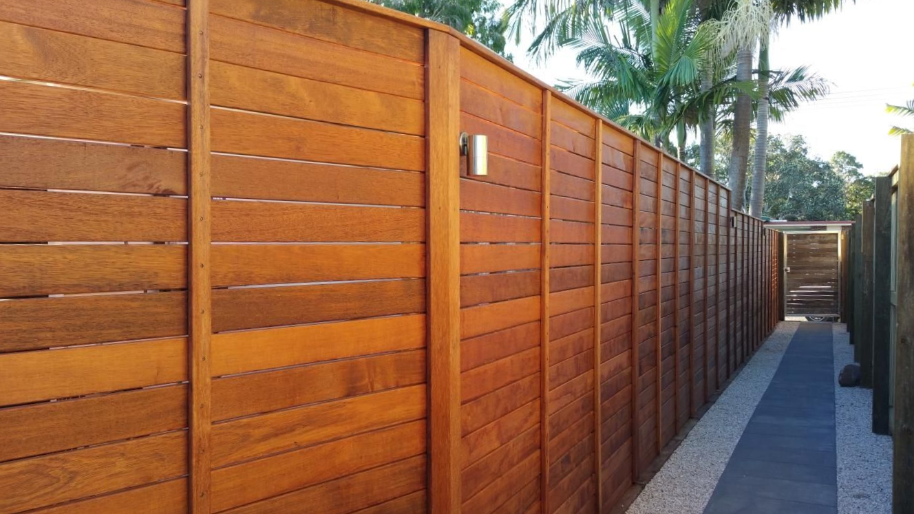 A Long Wooden Fence Along a Sidewalk with Gravel — Byron & Beyond Fencing In Billinudgel, NSW