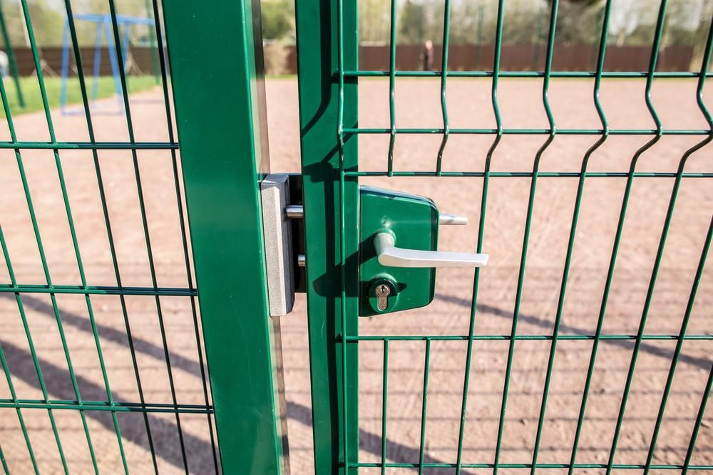 A Green Weldmesh Fence with A White Handle on It — Byron & Beyond Fencing In Billinudgel, NSW