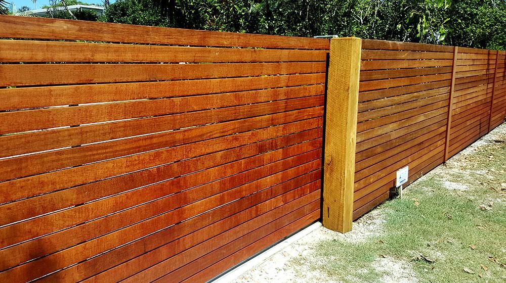 A Wooden Fence with A Wooden Post in The Middle of A Yard — Byron & Beyond Fencing In Billinudgel, NSW