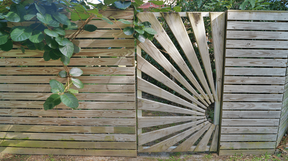 A Wooden Fence with A Gate that Looks Like a Sun — Byron & Beyond Fencing In Billinudgel, NSW