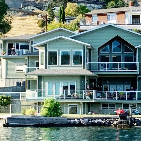 A large house sits on the shore of a lake