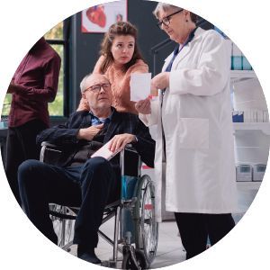A man in a wheelchair is being examined by two doctors.