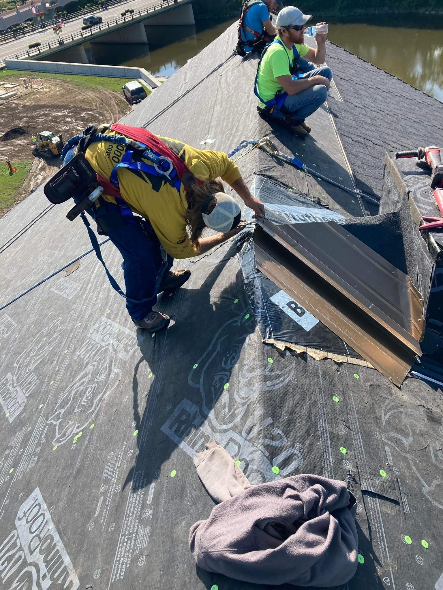 A group of construction workers are working on a roof.