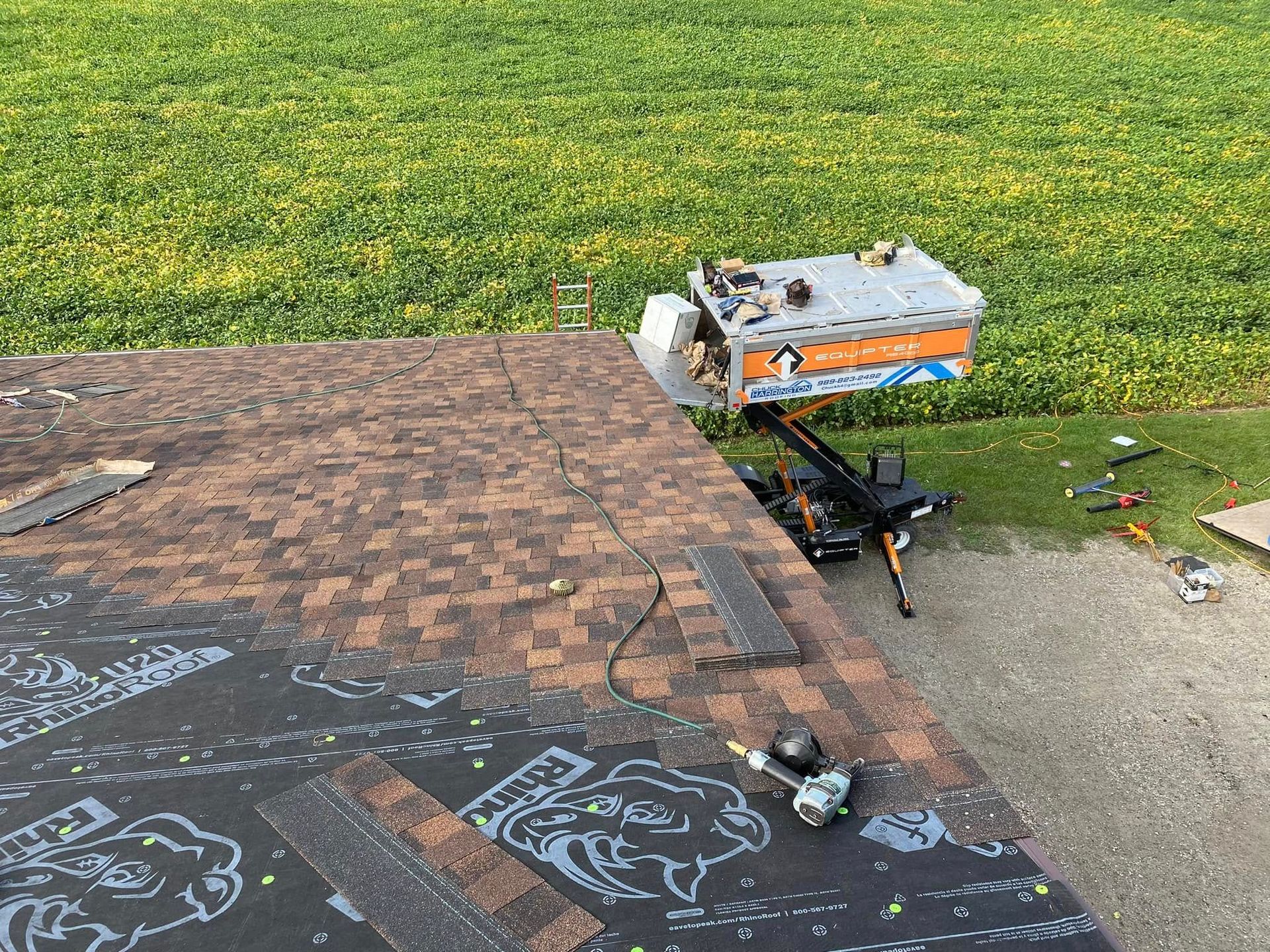 A roof is being repaired with a ladder and a box on top of it.
